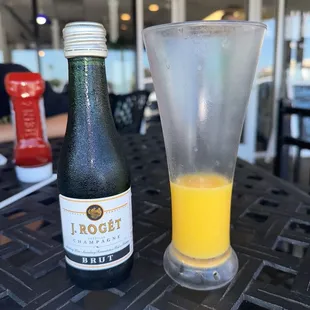 a bottle of beer and a glass of orange juice