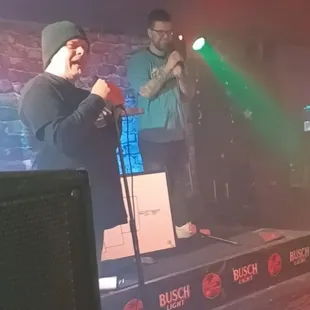 two men singing on stage