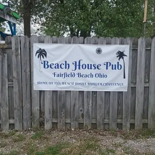 a sign in front of a fence