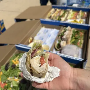 Catering order, 2 boxes of mixed sandwiches, 1 box of salad. Gluten-free wrap in foreground.