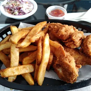Chicken tenders, fries and coleslaw.
