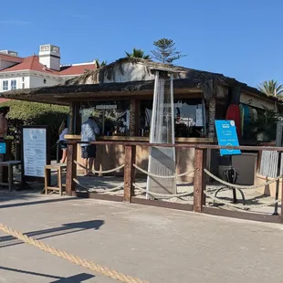 a man sitting on a bench in front of a bar