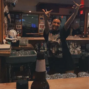 a man sitting at a bar with his arms in the air