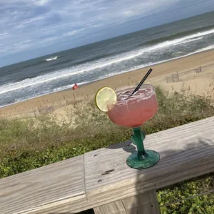 a pink drink with a slice of lime