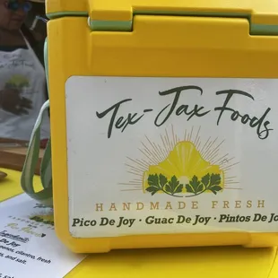 a yellow lunch box with a sticker on it