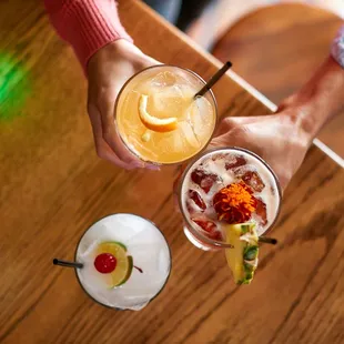 two people holding cocktails