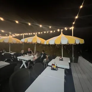 Outdoor seating with the cutest umbrellas and lights. Love eating by the beach!