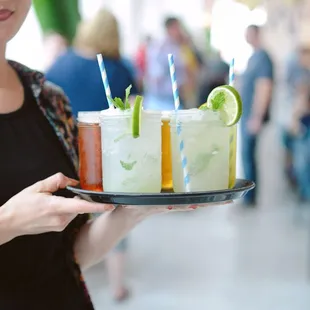a woman holding a tray of drinks