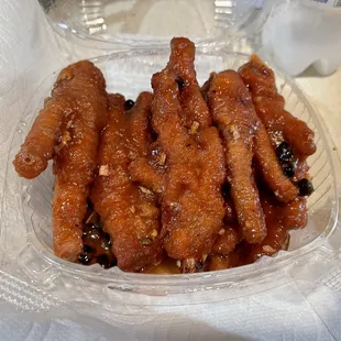 a clear plastic container filled with chicken wings