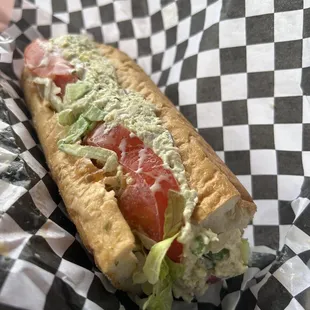 a sandwich with lettuce and tomatoes