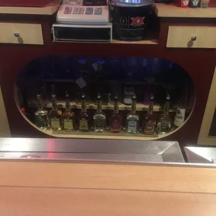 a counter with liquor bottles and a cash register