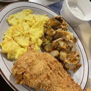 Country fried Chicken (breakfast) with scrambled eggs, fried potatoes and gravy on the side