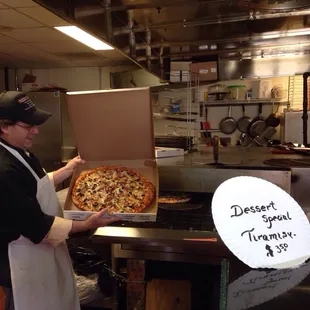 Owner showing the pizza