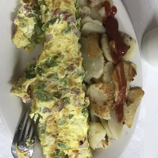 an omelet, potatoes, and ketchup