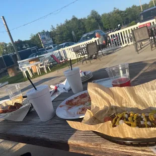 hotdogs and drinks on a picnic table