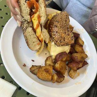 Bacon, egg, and cheese on an everything bagel with breakfast potatoes