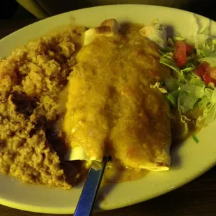Two beef burrito with beans and rice.