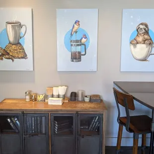 a coffee shop with three paintings on the wall