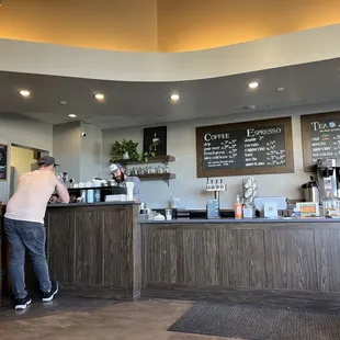 a man standing at the counter of a coffee shop