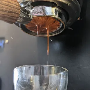 a glass of liquid being poured into a juicer