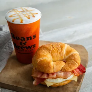 a croissant sandwich and a drink