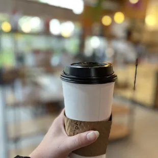  hand holding a coffee cup