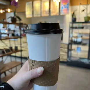  hand holding a coffee cup