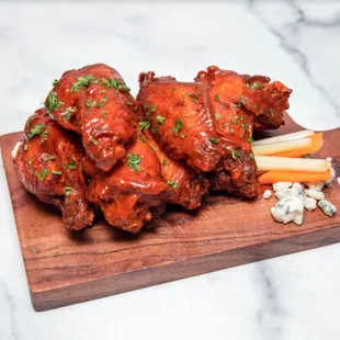 buffalo wings and carrots on a cutting board