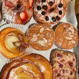 Strawberry and blueberry cronuts, Pecan roll, 2 coffee cake muffins, a cinnamon roll, and a maple bacon bar