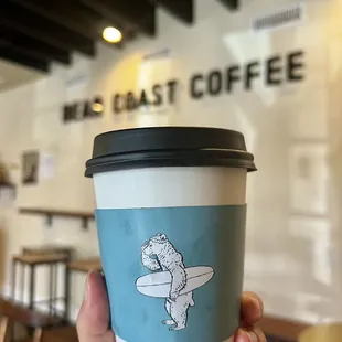 a hand holding a cup of coffee