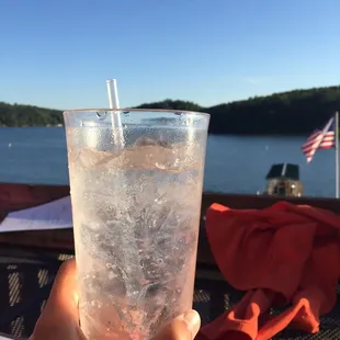 a hand holding a glass of ice water