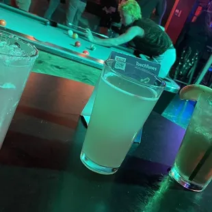 three different cocktails on a bar