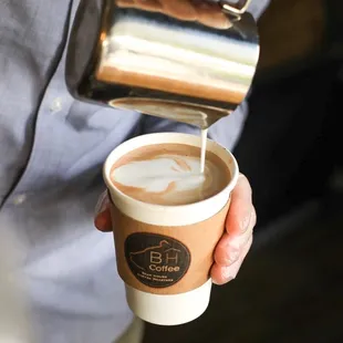a person pouring coffee into a cup