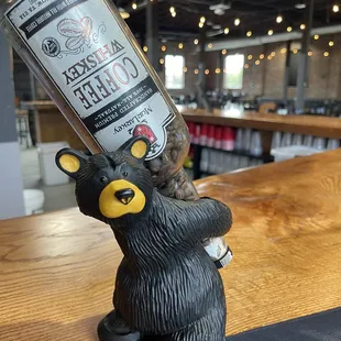 a bear holding a bottle of coffee