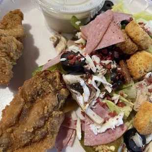 a plate of food with chicken, salad, and breaded croutons