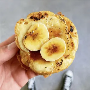 a person holding up a banana muffin