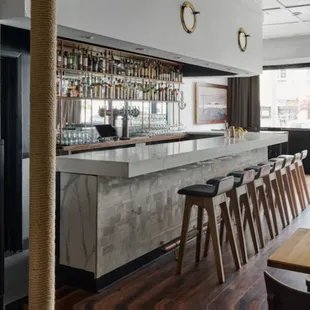 a bar with stools and a long counter