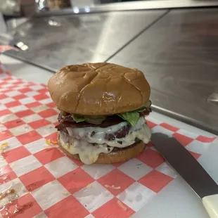 a burger on a table with a knife