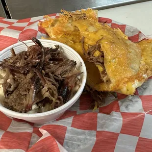 a pulled pork sandwich with a side of macaroni and cheese