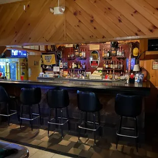 a bar with stools and a pool table