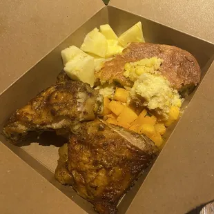 Baked chicken, corn pudding, butternut squash, and some slice pineapples