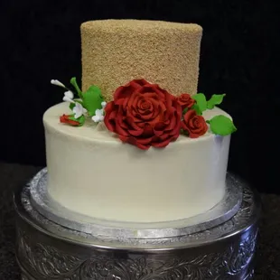a three tiered cake with red roses
