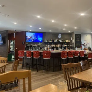 a bar with red chairs