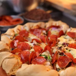 a pepperoni pizza on a wooden platter