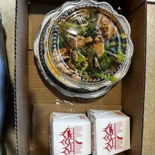 a bowl of broccoli and two boxes of rice