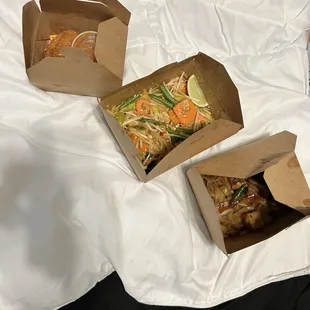 three boxes of food on a bed