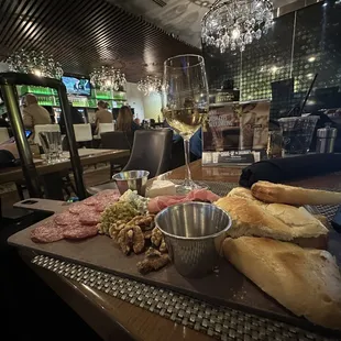 a platter of meats, breads, and wine