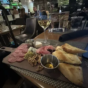 a platter of meats, breads, and wine