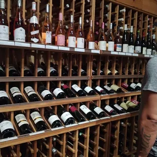a man standing in front of a wine rack