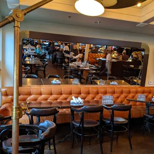 Cushy banquette seating and large mirrors add to the overall ambiance of the restaurant.